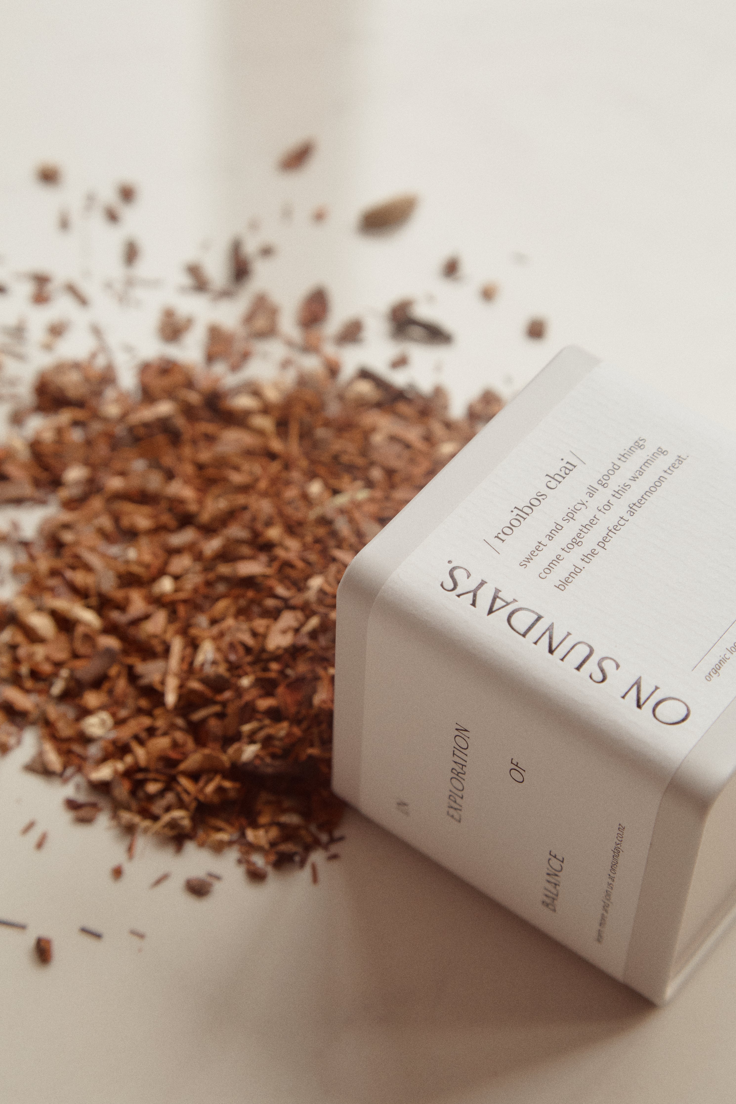 On Sundays tin of on sundays rooibos chai organic loose leaf tea open and spilling out onto a table