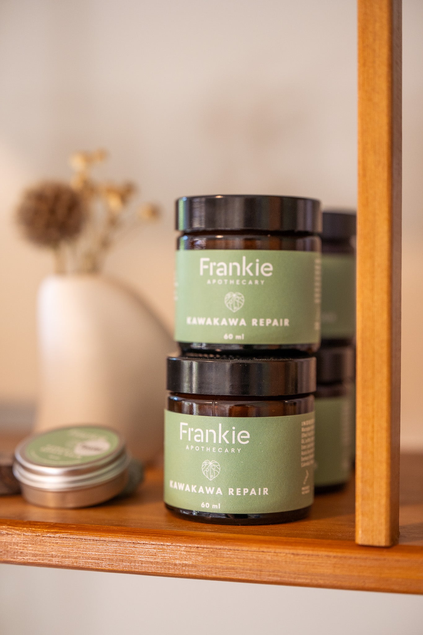 Frankie Apothecary Kawakawa repair balm stacked on a shop shelf