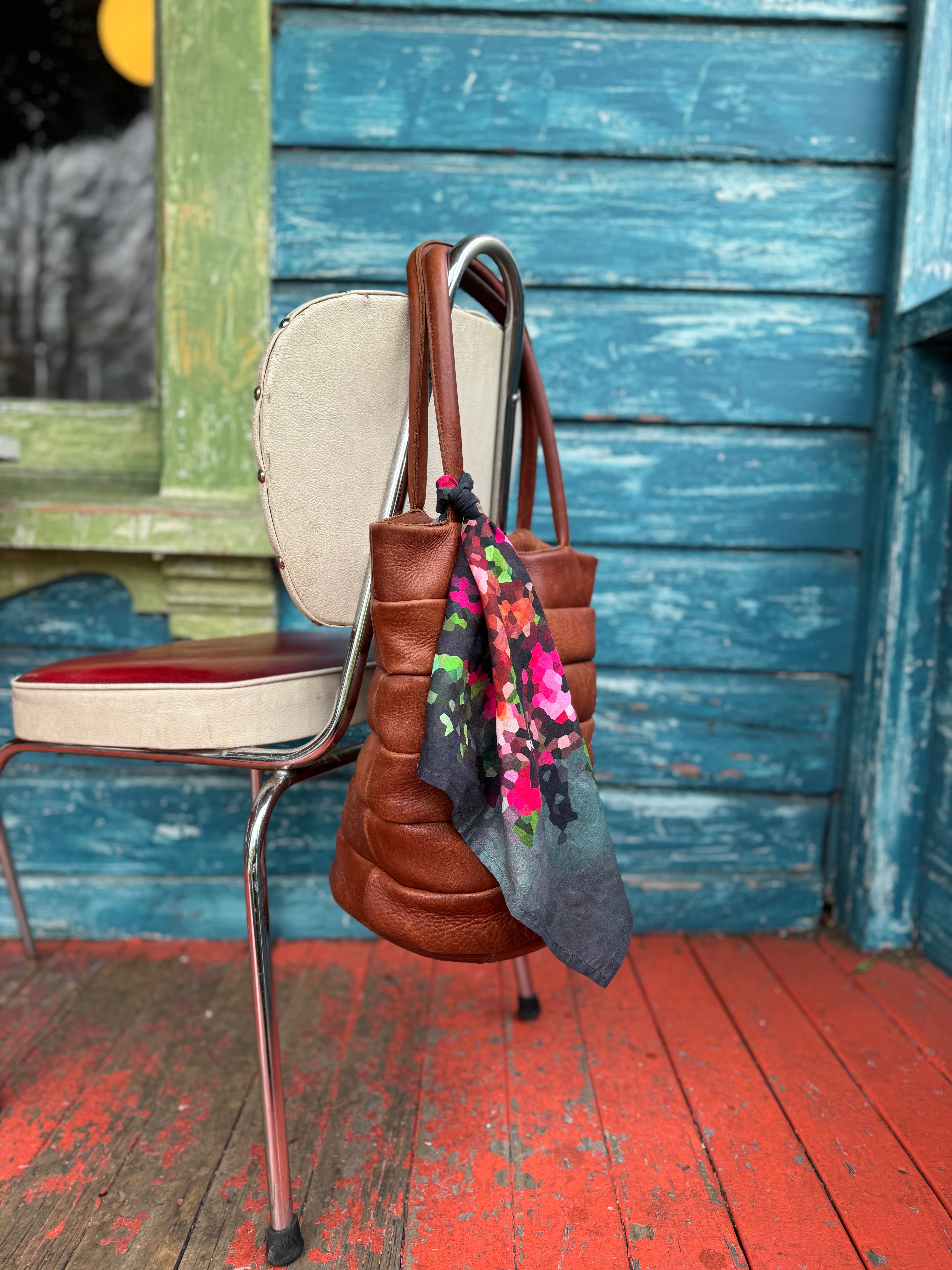 A HANK handkerchief being shown as an adornment on a handbag