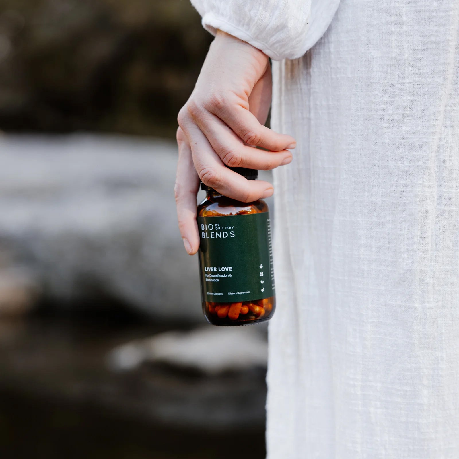 Woman holding bio blends liver love supplement bottle