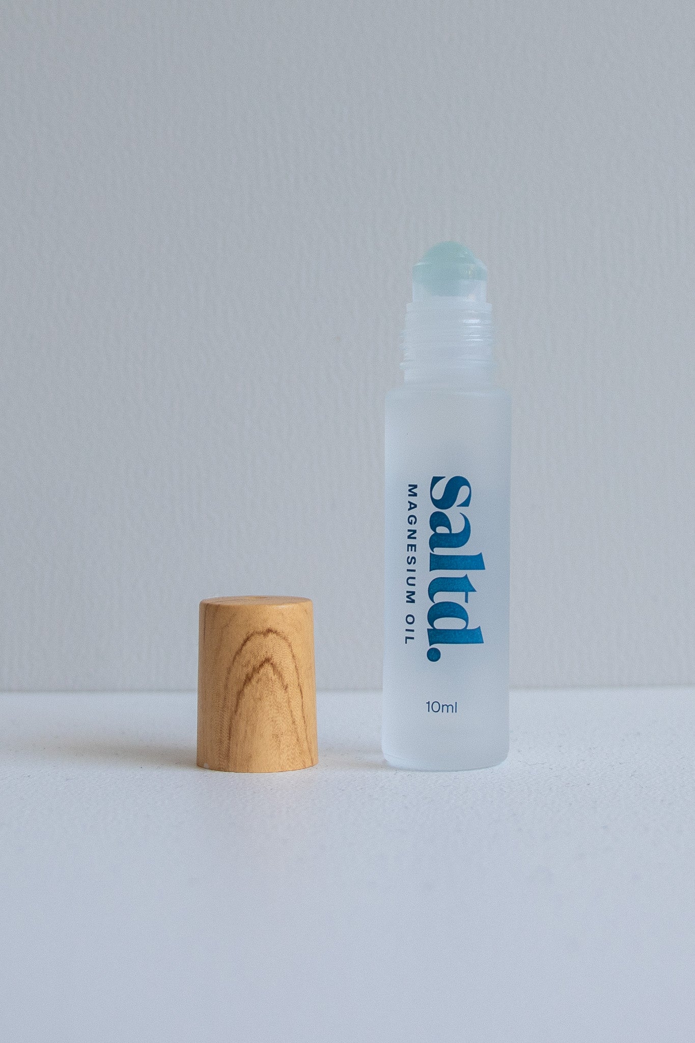 Clear bottle labeled 'saltb' with a wooden cap on a light gray background