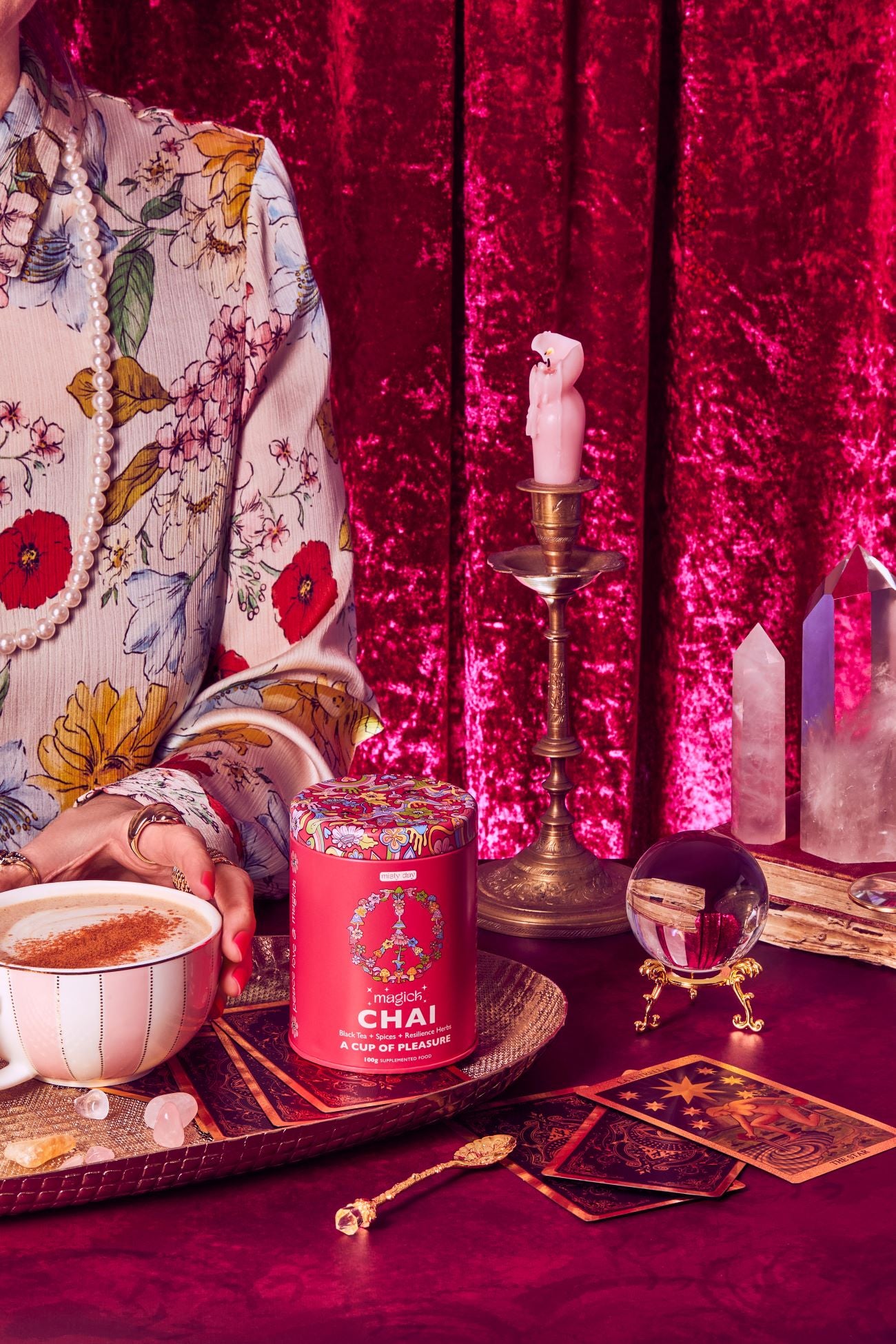Misty Day Plant Potion Magick Chai set on a red table with a cup of chai and candles and oracles and crystals