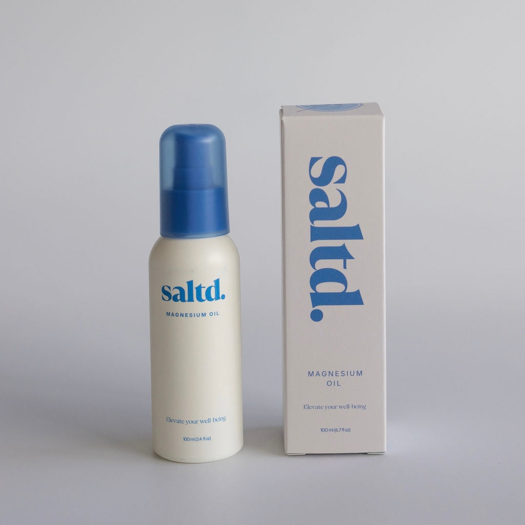 Saltd magnesium oil bottle and packaging on a gray background