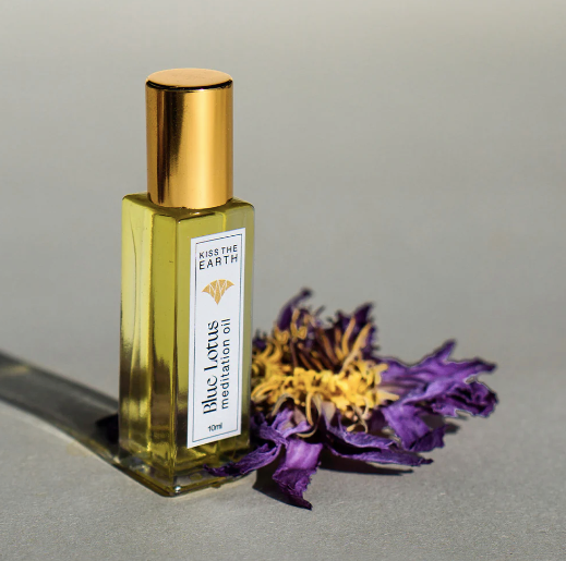 Kiss the Earth blue lotus meditation oil and a blue lotus flower