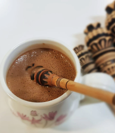 Cup of cacao with a molinillo whisk in it