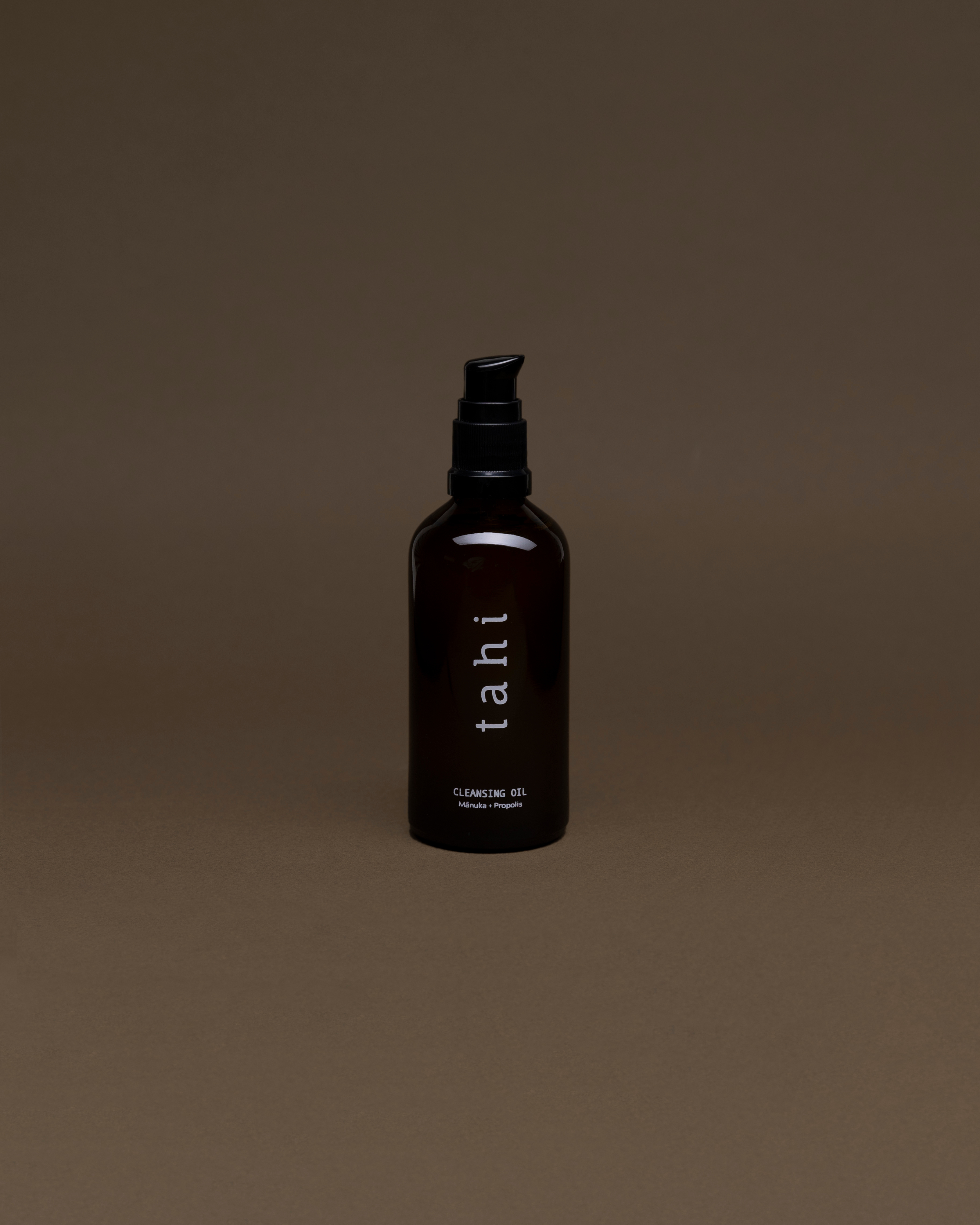 Black bottle labeled 'tahi' on a brown background