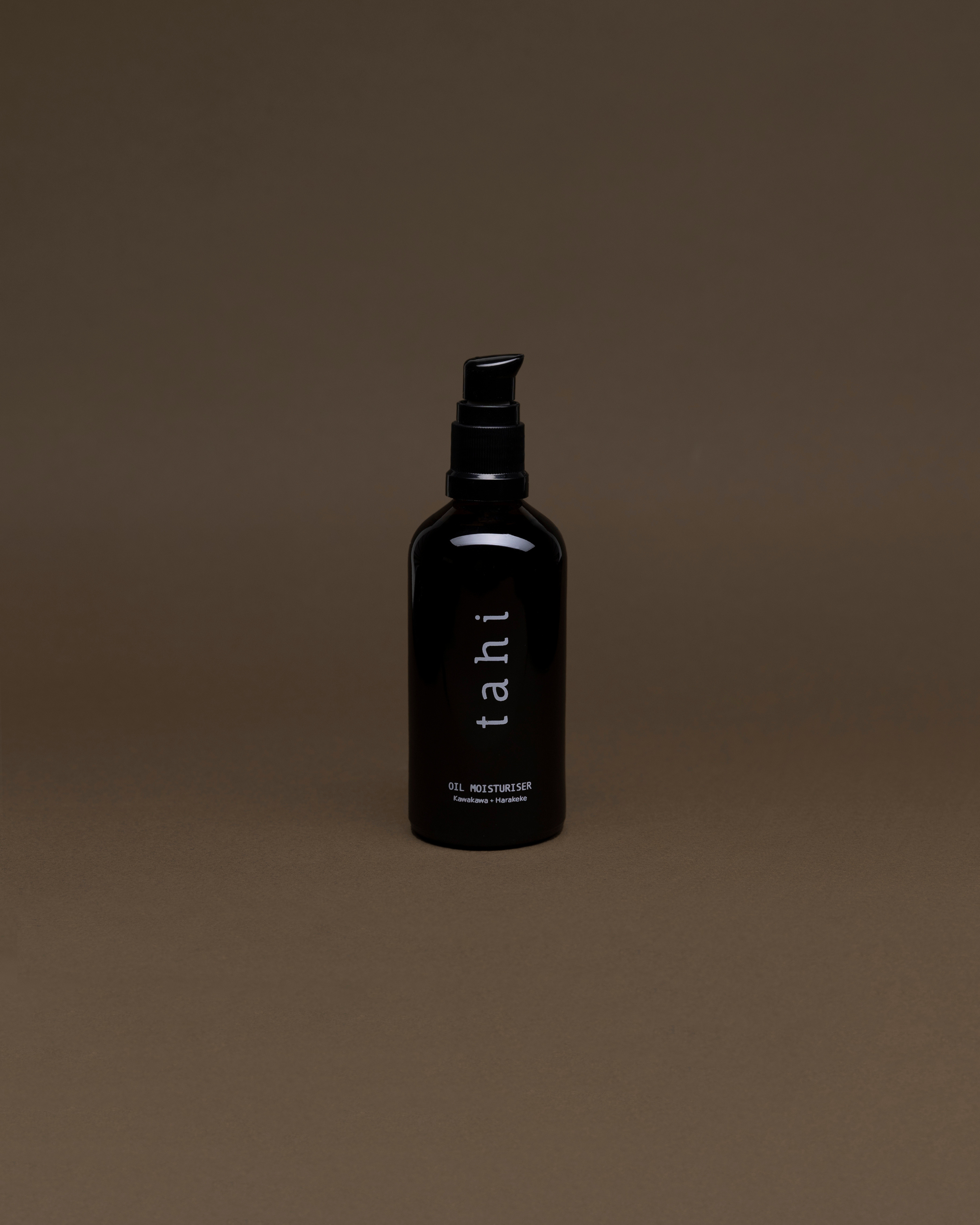 Black bottle labeled 'tahi' on a brown background