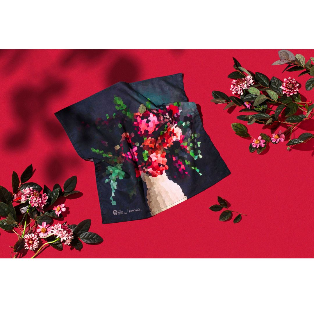A HANK handkerchief being displayed on a red background with floral arrangements