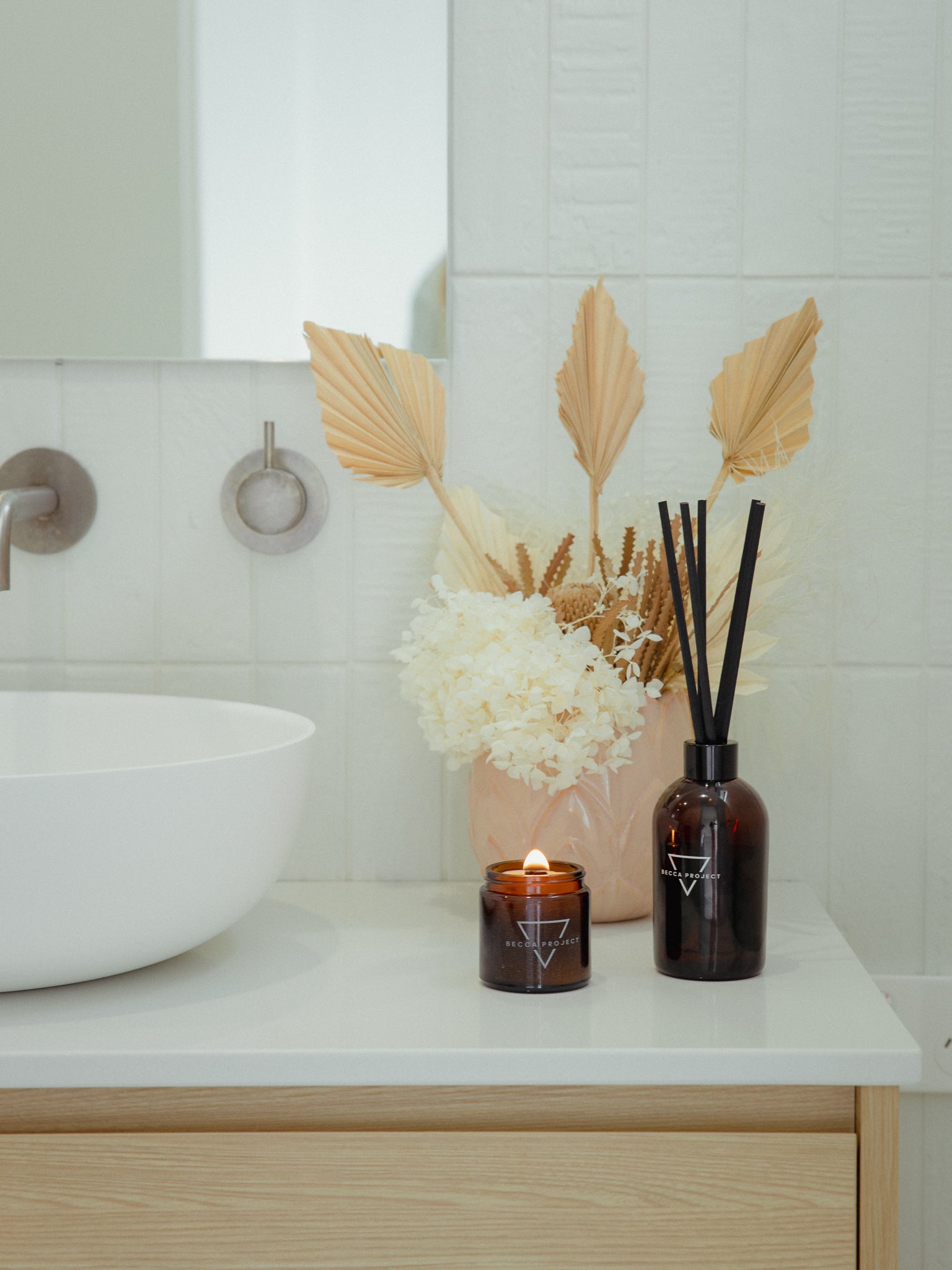 Becca Project candle and reed diffuser in a bathroom setting