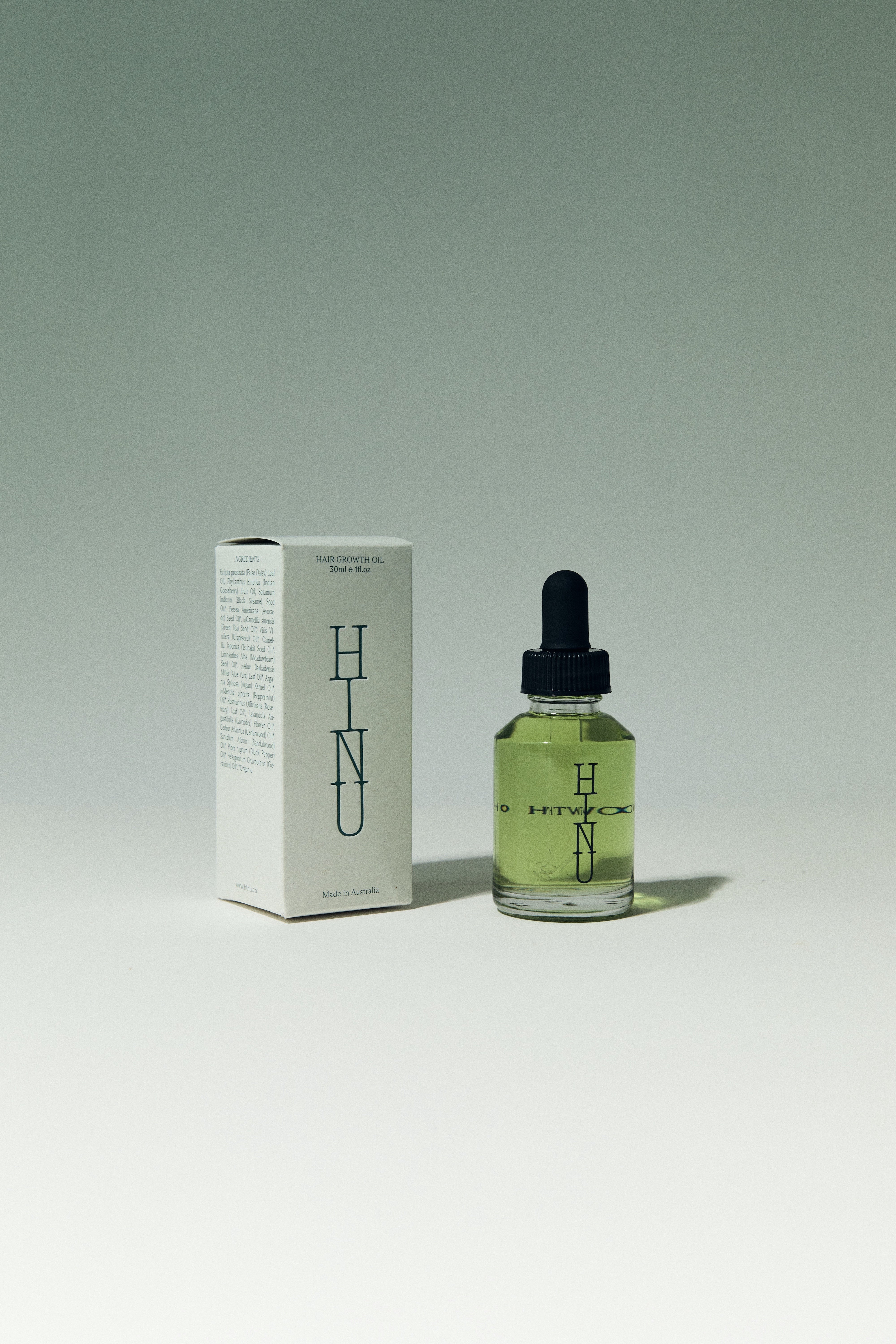 HINU hair growth oil and box packaging on a white background