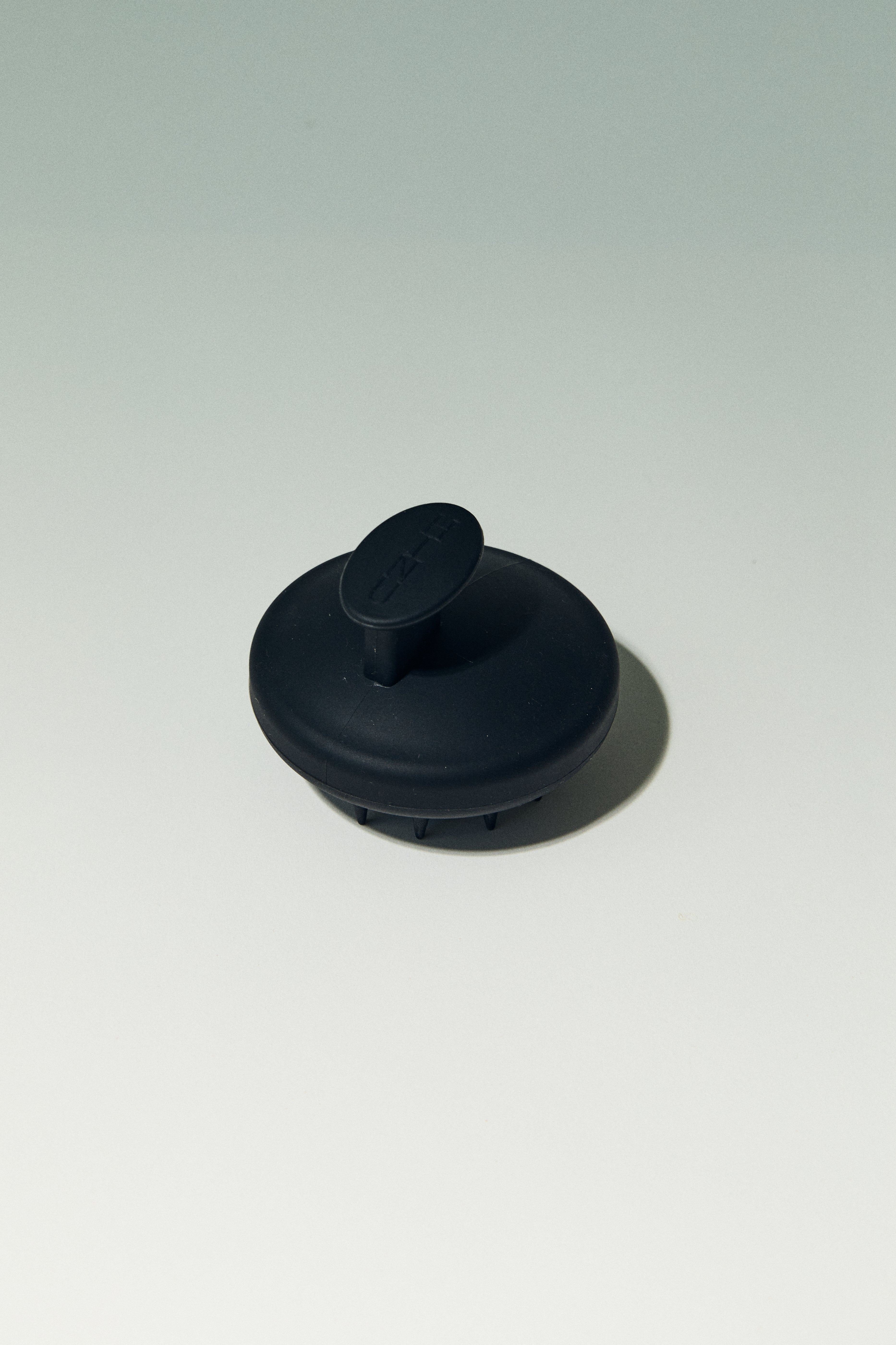 black scalp hair massager on a white background