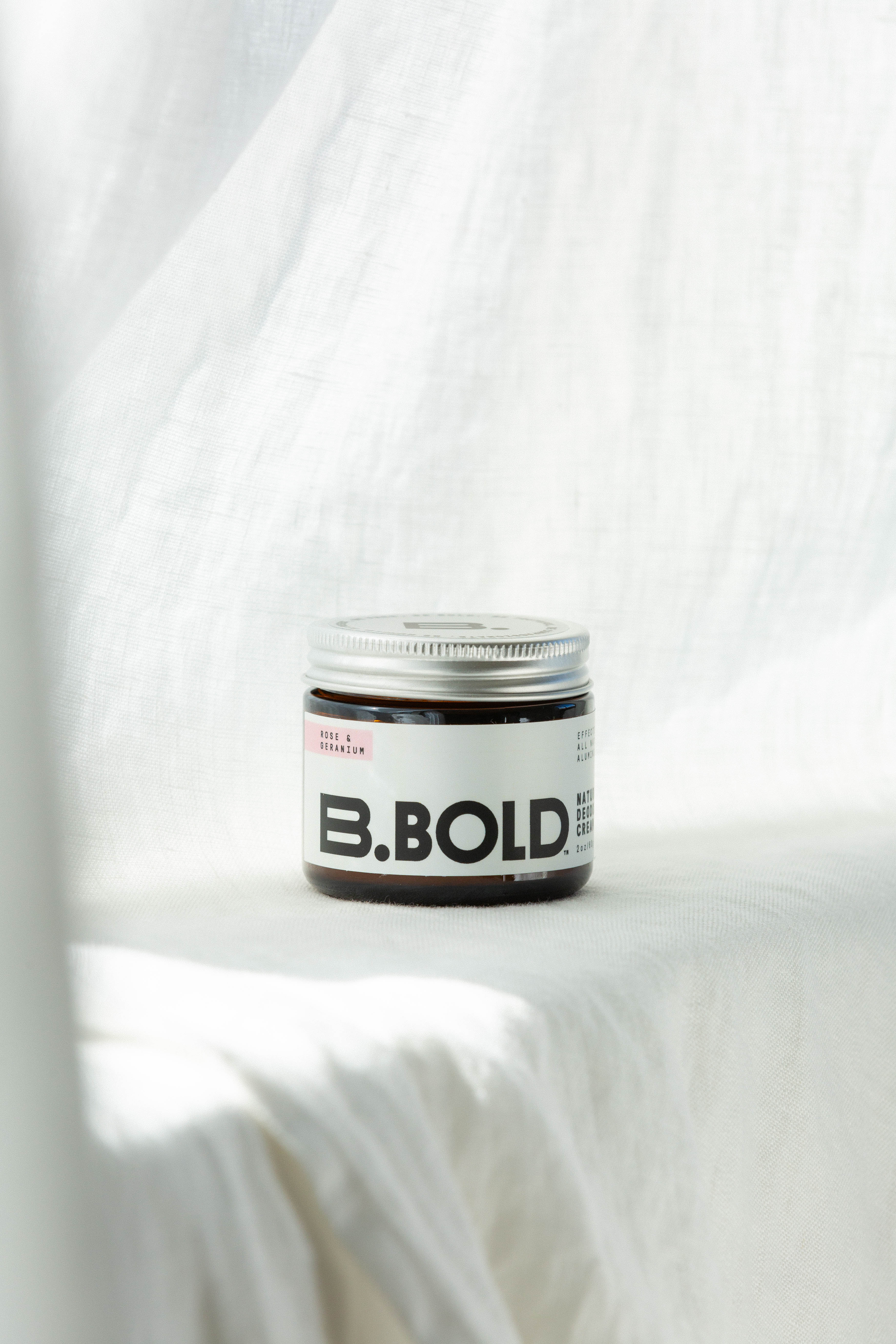 B.bold natural rose and geranium deodorant on white background