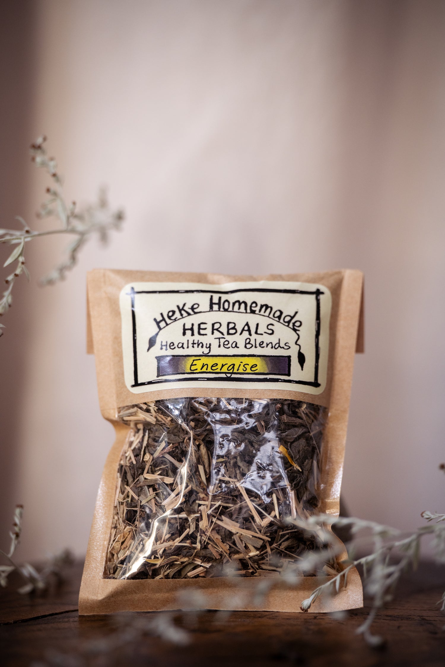 Packaged tea blend labeled 'Heke Herbals - Energise Tea' with visible dried herbs through the transparent packaging.