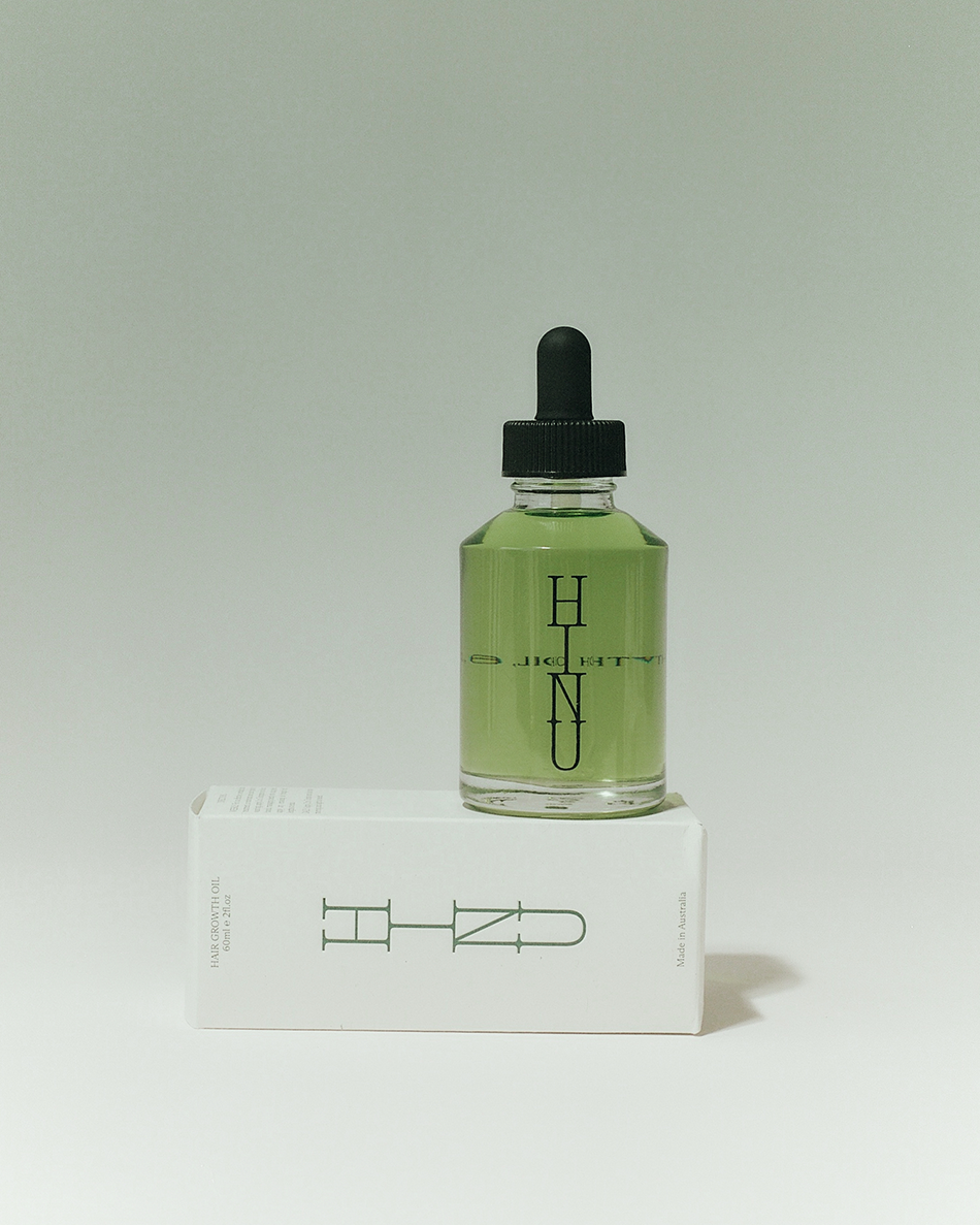 Green bottle with dropper and black cap on a white box with 'HINU' branding against a light gray background