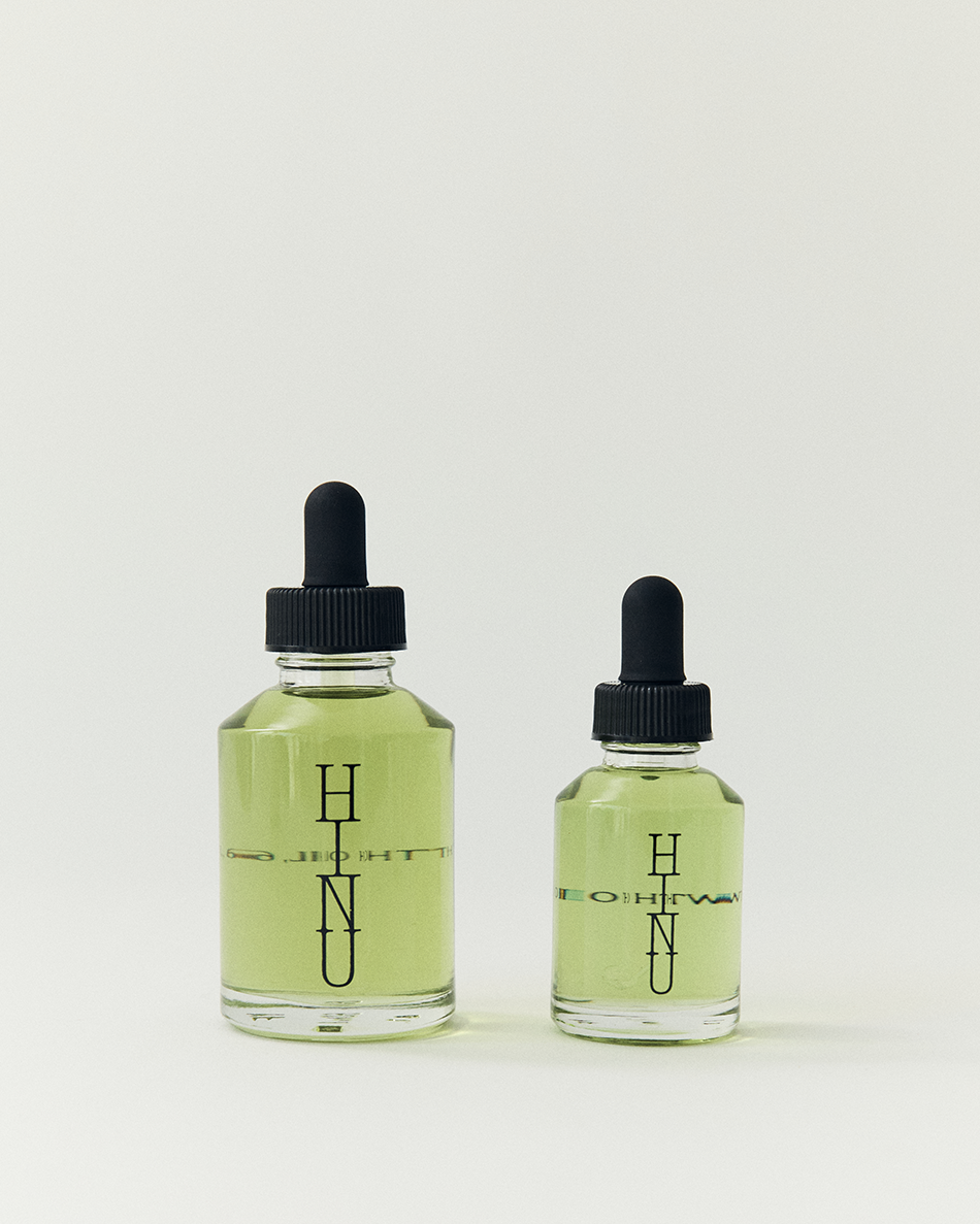 Two bottles of HINU hair growth oil on a white background
