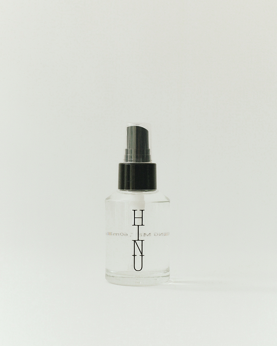 Clear spray bottle with black cap and 'HINU' branding on a white background