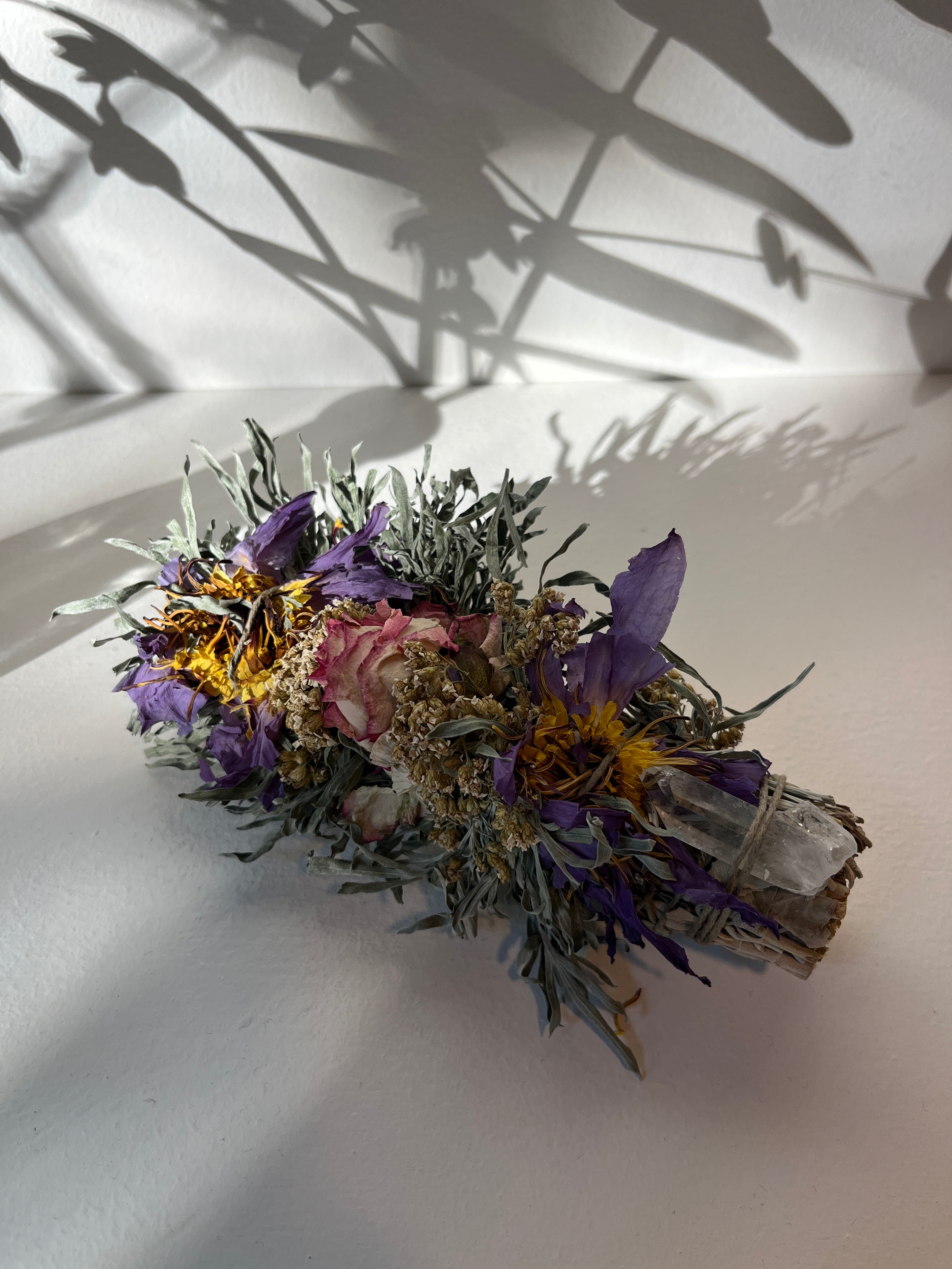 dried flowers, sage and crystal on a white background