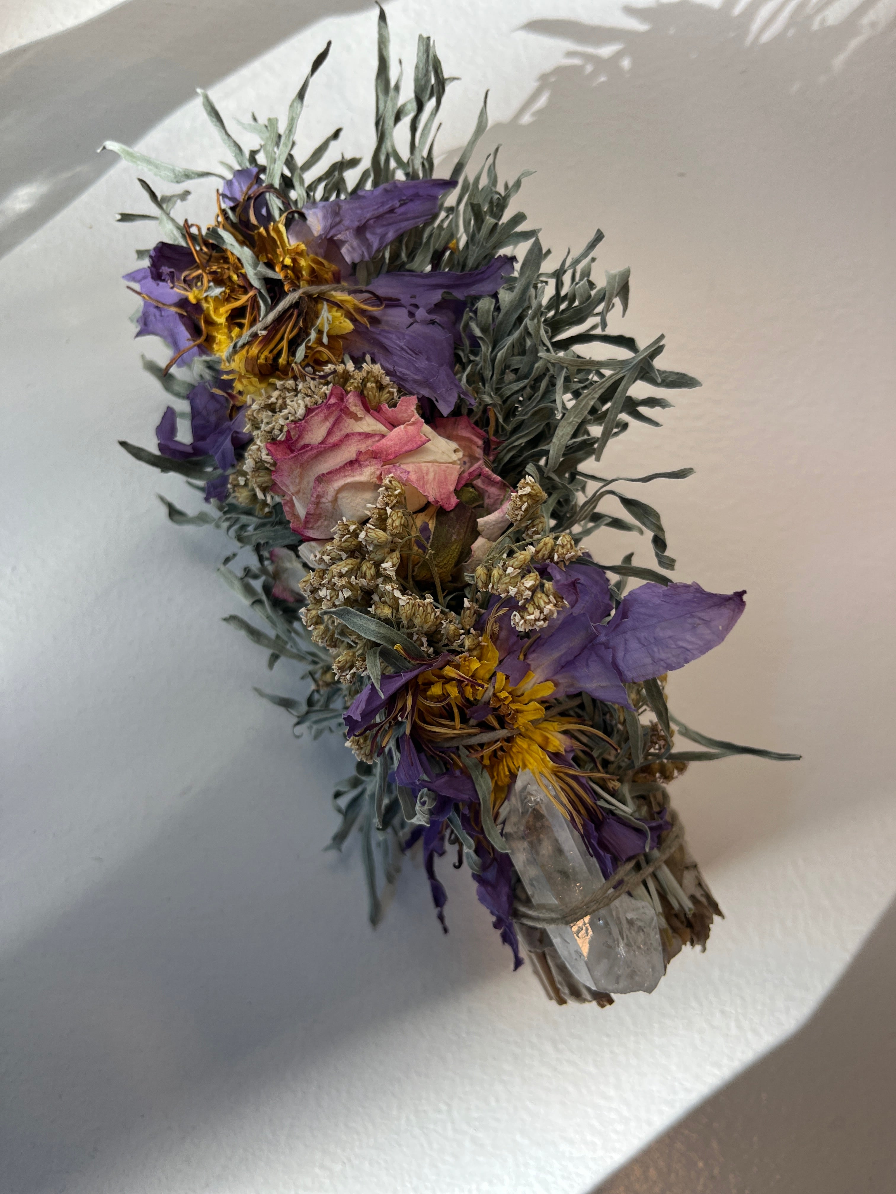 Dried flowers and crystals on a white surface