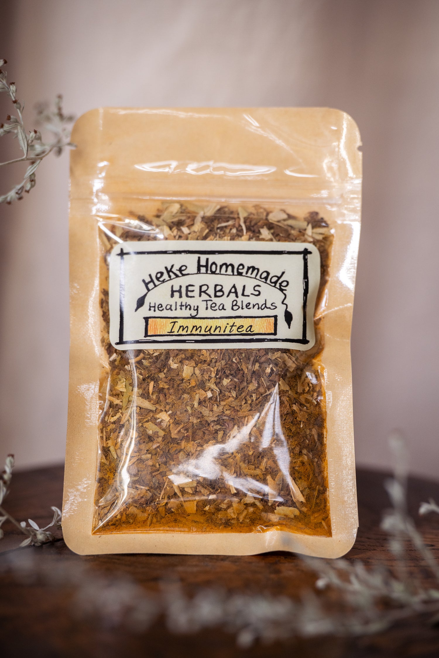 Packaged tea blend labeled 'Heke Herbals - ImmuniTea' with visible dried herbs through the clear front of the packaging.