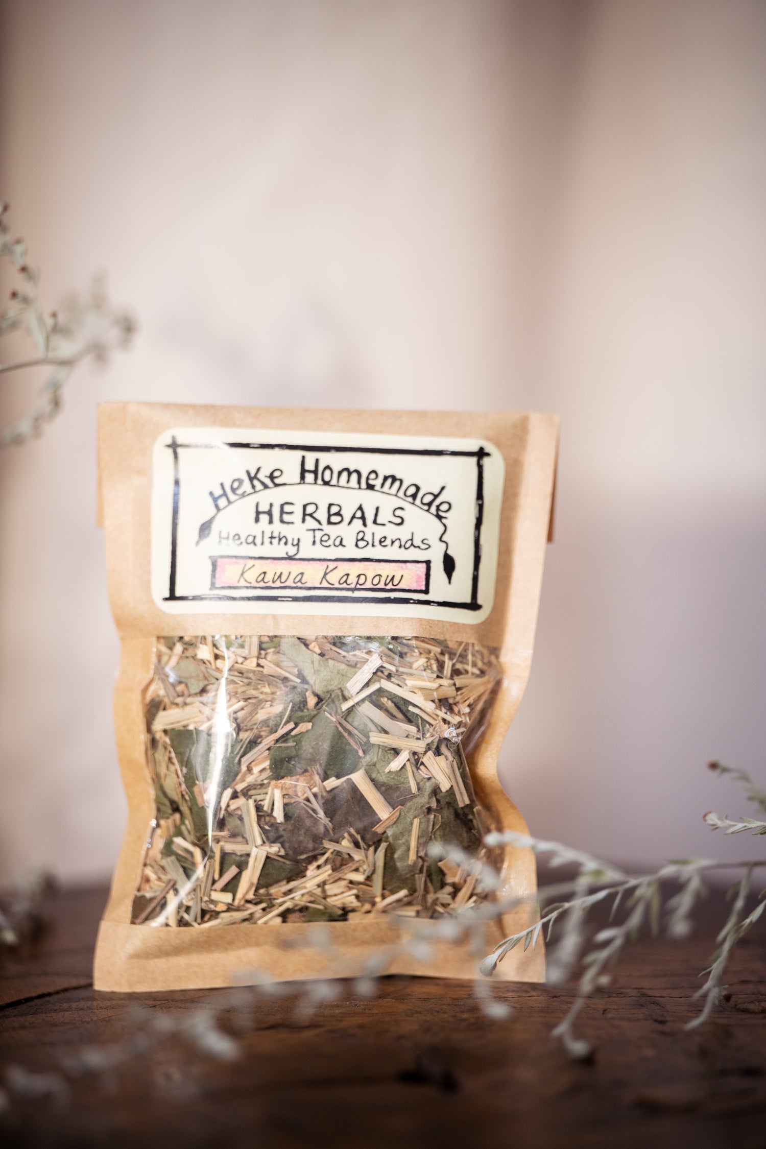 Packaged tea blend labeled Heke Herbals Kawa Kapow Tea, visible through a clear window showing the dried herbs inside.
