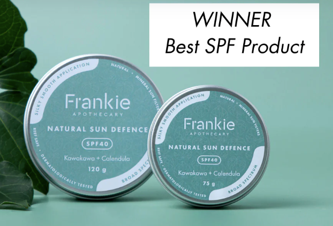 Two tins of Frankie Natural Sun Defence SPF40 sunscreen, with a leafy background. The tins are labeled with the brand name and product details.
