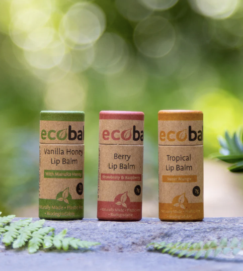 Three Ecobalm lip balms in different flavors on a natural background.