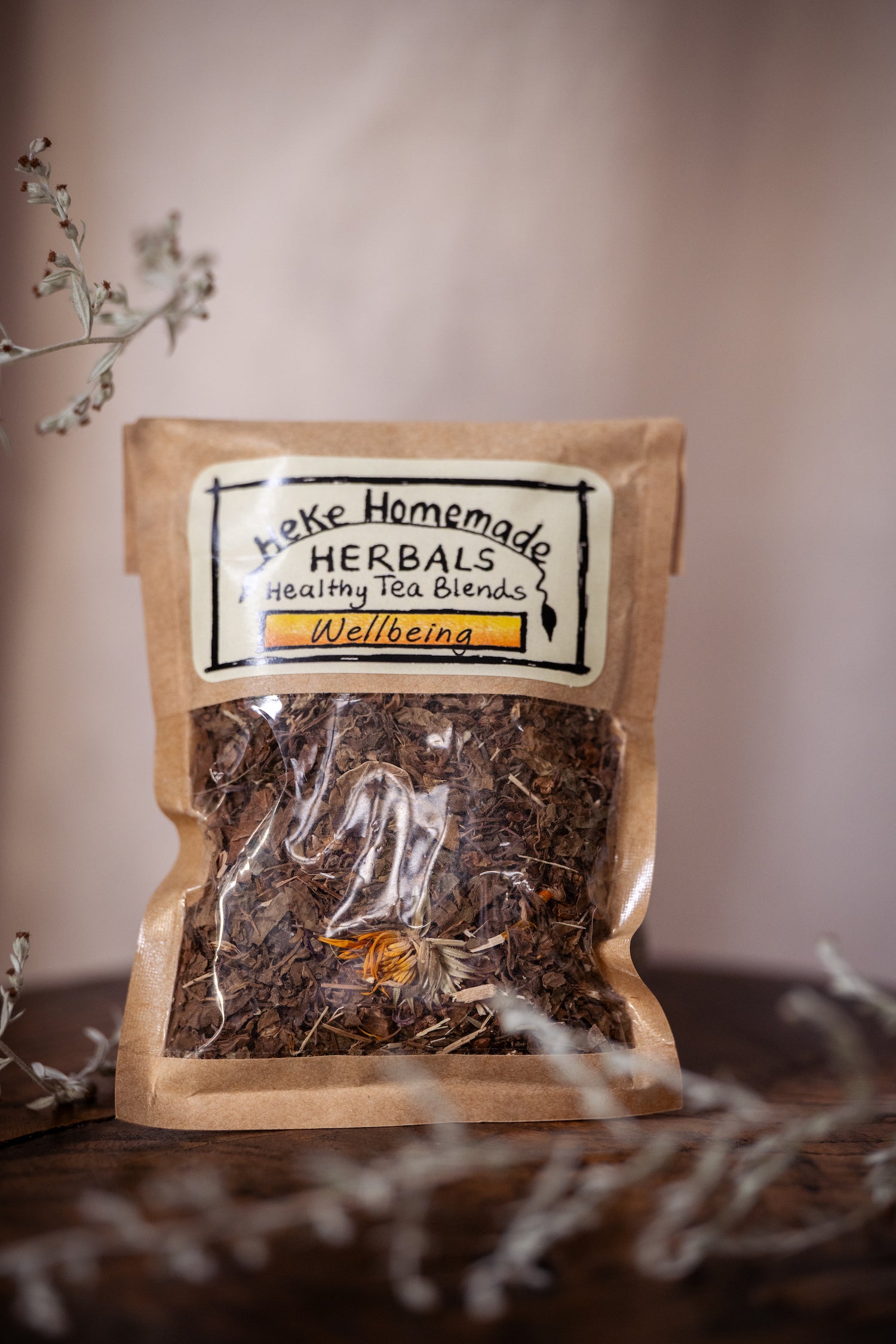 Packaged loose tea blend from Heke Herbals, labeled as 'Wellbeing Tea', with visible ingredients such as tulsi, thyme, and calendula.
